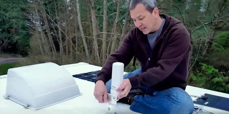 man installing a weboost cell phone signal booster in an RV